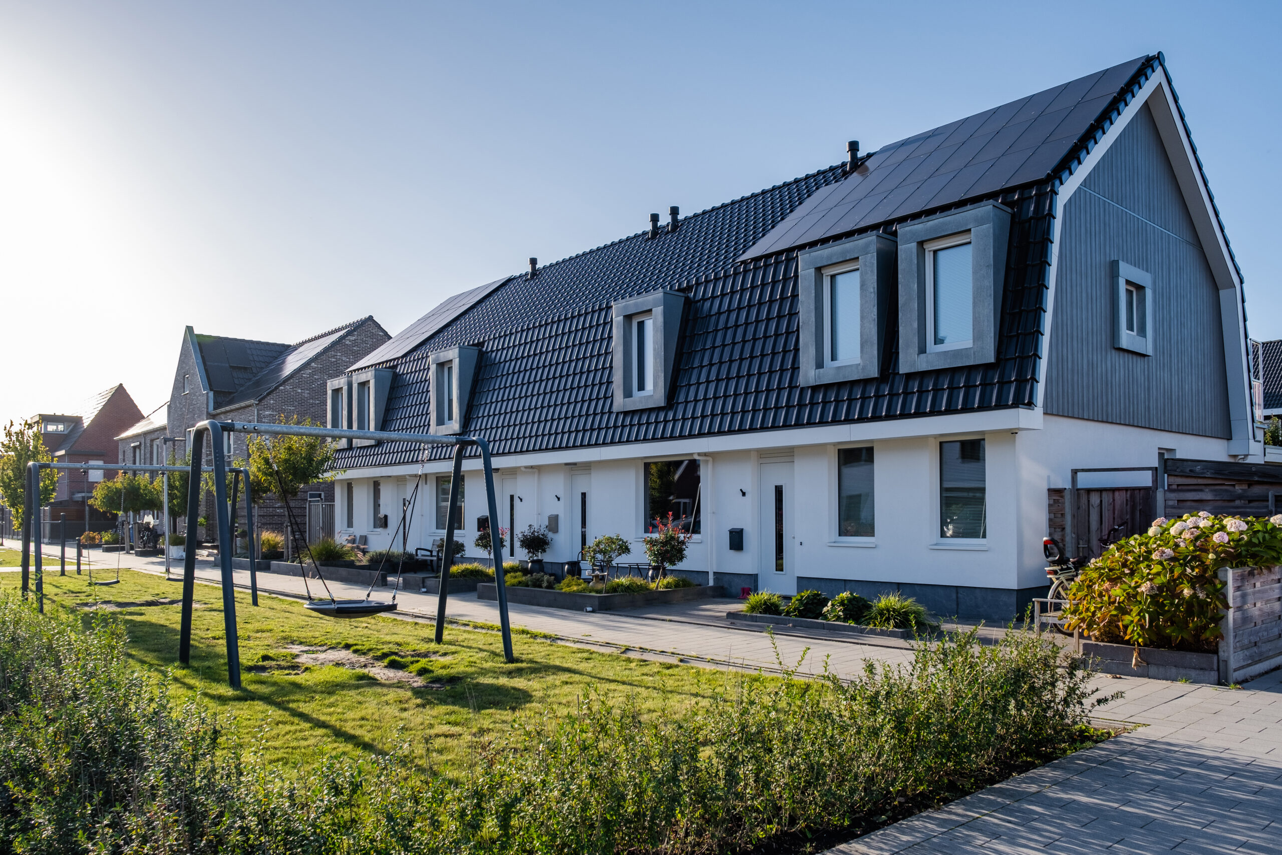 Vorort mit modernen Einfamilienhäusern, neu gebaute moderne Einfamilienhäuser mit Solarmodulen auf dem Dach.