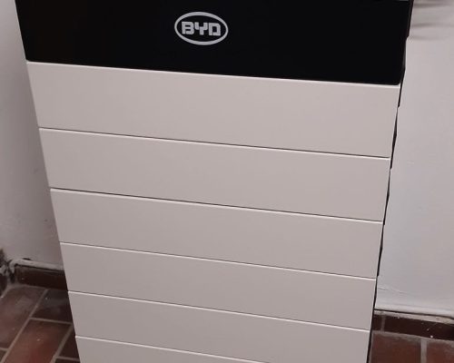 Schwarz-weißer BYD Speicher auf einem gekachelten Kellerboden.