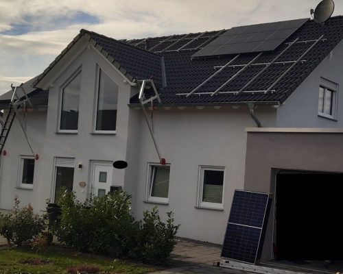 Wenige Module auf einem Dach. Unterkonstruktion installiert. Bauphase.