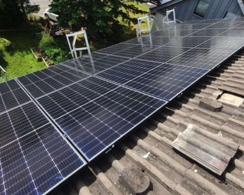 Eine Solaranlage auf einem Dach in Leverkusen. Sicht von der Dachspitze zum Rasen, auf dem Boden.