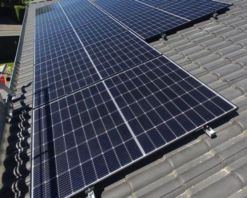 Einige Solarmodule auf einem grauen Dach.