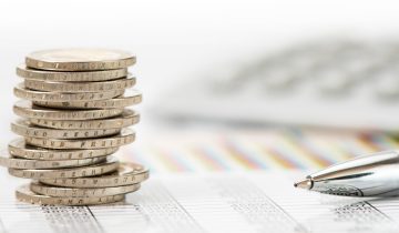 Stapel Euro Münzen auf Chart und Zahlentabelle