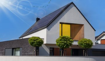 Solar panels on the roof. Beautiful modern house and solar energy. The rays of the sun and the light in the window.